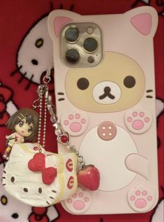 a cell phone case with a cat and heart charm on it