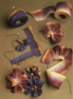 several different types of fabric and scissors on a table with some flowers in the middle