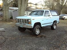 a light blue pick up truck parked in front of a house