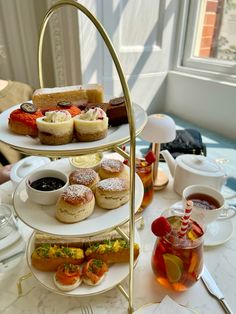 three tiered trays filled with pastries and drinks