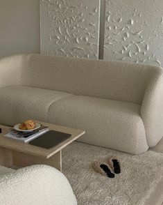 a living room with a couch, coffee table and rugs on the floor in front of it