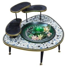 a table that has two tables on it with flowers in the center and one sitting on top