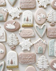 many decorated cookies are displayed on a white surface with snowflakes, trees, and mittens