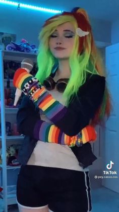 a woman with green hair and rainbow colored wig