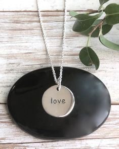 Silver Love Necklace | The Life Divine Our solid sterling silver double sided round disk charm is engraved with the word "Love" This round disk charm measures a 1/2" in diameter. You may purchase the charm on its own or on a shimmering diamond cut ball chain.Select from 3 different Lengths -16”, 18” or 20” Disk Necklace, Motivational Jewelry, The Word Love, Anniversary Necklace, Word Love, Love Charms, Disc Necklace, Energy Crystals, Love Necklace