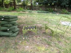 a pile of green chairs sitting next to each other on top of a grass covered field