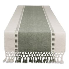 a table runner with tassels on the edge and an off - white border