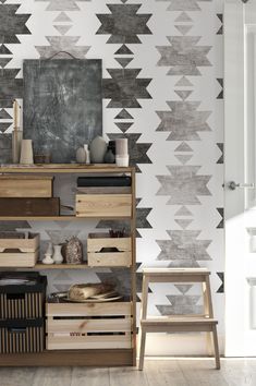 a wooden shelf with drawers and baskets in front of a patterned wall