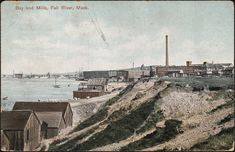 an old photo of a city on the edge of a hill overlooking water and buildings