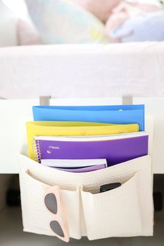 a stack of folders sitting in a drawer next to a child's bed