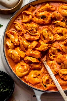 a pot filled with pasta and sauce on top of a table