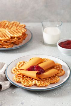 some waffles with ketchup and jelly on them are sitting on plates