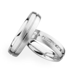 two white gold wedding rings with diamonds on each one and the other side, set in 18k white gold