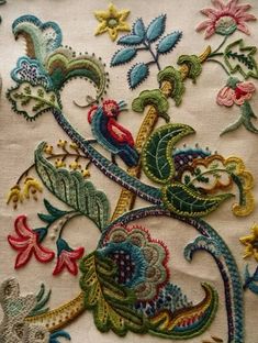 an embroidered fabric with flowers and birds on it