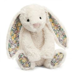 a white stuffed rabbit with floral designs on it's ears and legs, sitting in front of a white background