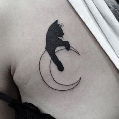 a black cat sitting on top of a crescent tattoo