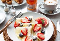 crepes with berries and powdered sugar on a plate