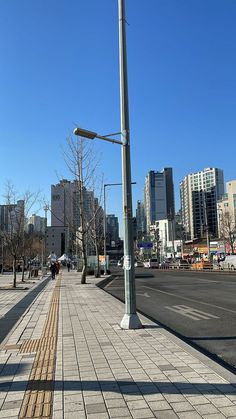 an empty city street with no cars on it and tall buildings in the back ground