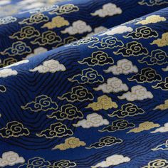 the blue and gold fabric has clouds on it