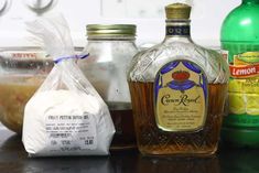 bottles of liquor sitting on top of a counter next to other ingredients and condiments