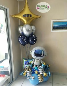 an astronaut balloon sitting on top of a blue box filled with helium and other items