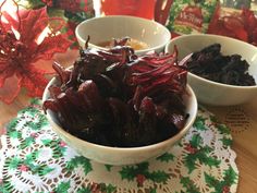 two white bowls filled with dried cherries on top of a doily covered table