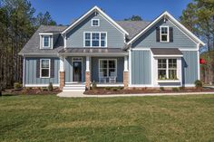 a house with blue siding and white trim on the front door, windows, and shutters