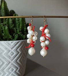 Handmade cluster earrings made with Freshwater Pearls, white color, and Red Coral branches. GOLD PLATED 925 STERLING SILVER Lenght : 5 cm / 1,97 inches * SHIPPING * Your order will be shipped within 1-3 business days from your purchase. You can choose between 2 shipping methods: STANDARD MAIL (NOT TRACEABLE) It is a cheap and fast shipping method, but NOT TRACEABLE. Chapeau Atelier is not responsible for any postal disruptions, delays or losses. REGISTERED MAIL (TRACEABLE) It is an absolutely sa Handmade Red Pearl Earrings For Party, Coral Jewelry Gift With Ear Wire, Coral Jewelry With Ear Wire For Gift, Handmade Coral Drop Earrings, Handmade Coral Dangle Jewelry, Handmade White Dangle Cluster Earrings, Handmade Coral Jewelry For Party, Handmade Cluster Earrings As Gift, Coral Dangle Earrings