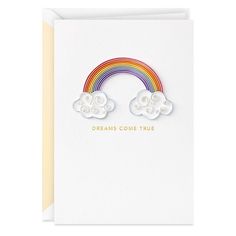 a white card with two clouds and a rainbow on the front that says dreams come true