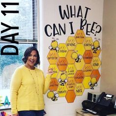 a woman standing in front of a sign that says what can i bee? with bees on it