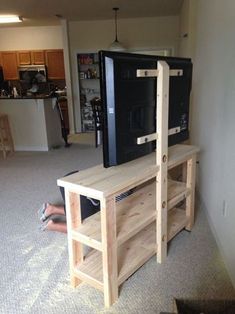 a person laying on the floor in front of a television and entertainment center that is made out of wood