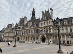 a large building with many windows and lots of people walking around in front of it