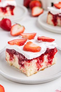 a slice of strawberry shortcake on a plate with whipped cream and strawberries in the background