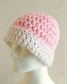 a white mannequin head wearing a pink and white crocheted hat