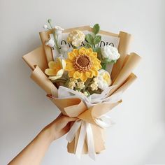 a person holding a bouquet of flowers with the word love written on it in front of them