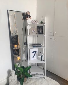 a white shelf with a stuffed animal on top of it next to a large mirror