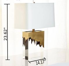 a table lamp sitting on top of a white floor next to a wall with measurements