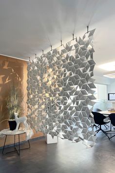 a room divider in the shape of hexagonal cubes with chairs and tables