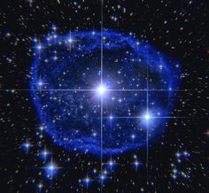 a blue star surrounded by stars in the night sky