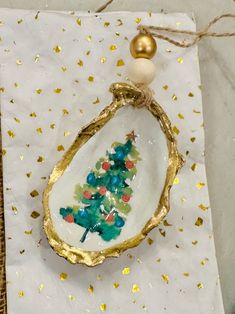 an ornament with a christmas tree on it is sitting on a piece of paper