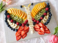 a butterfly made out of sliced fruit and berries