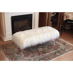 a white bench sitting on top of a rug next to a fire place in a living room