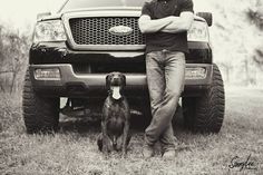 a man standing next to a dog in front of a truck