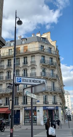 a street sign in front of a tall building with balconies on the windows