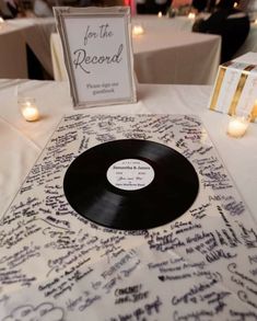 a record sitting on top of a table next to candles and a sign that says for the record