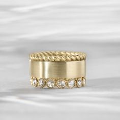 a yellow gold ring with five diamonds on the inside and outside, set against a white background