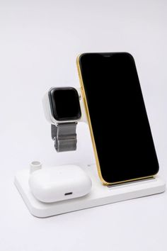 an apple watch and iphone charging station on a white surface with gold trimmings