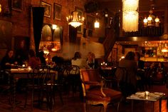 people sitting at tables in a dimly lit restaurant