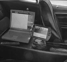 a laptop computer sitting on top of a desk next to a cell phone and other electronics