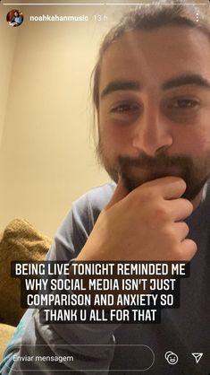 a man with long hair and beard is looking at the camera while holding his hand over his mouth